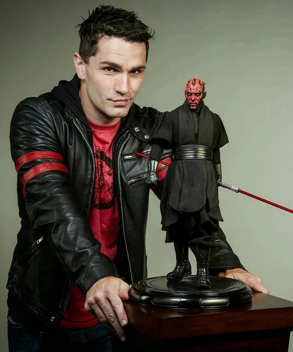 Actor Sam Witwer wearing vintage slim fit black leather cafe racer jacket with red stripe detailing beside Darth Maul collectible figure