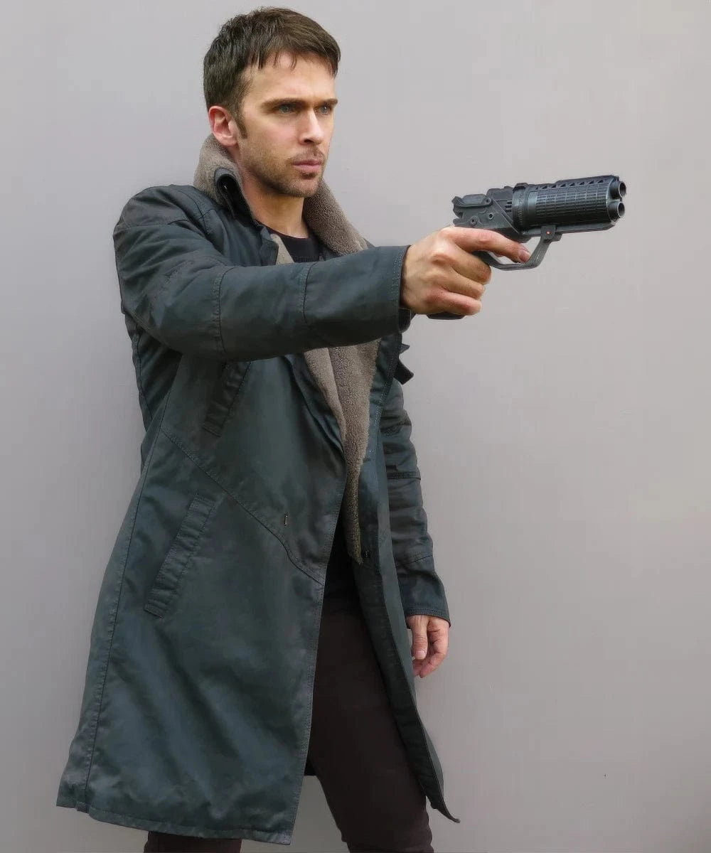 Man wearing the Blade Runner 2049 coat in an action shot with a blaster gun.