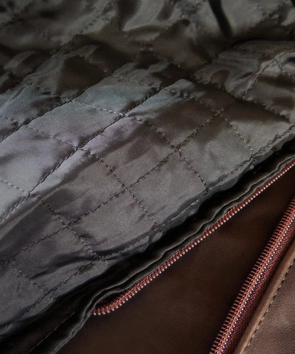 Close-up view of quilted black lining and inner zipper detail inside vintage slim fit brown calf leather jacket