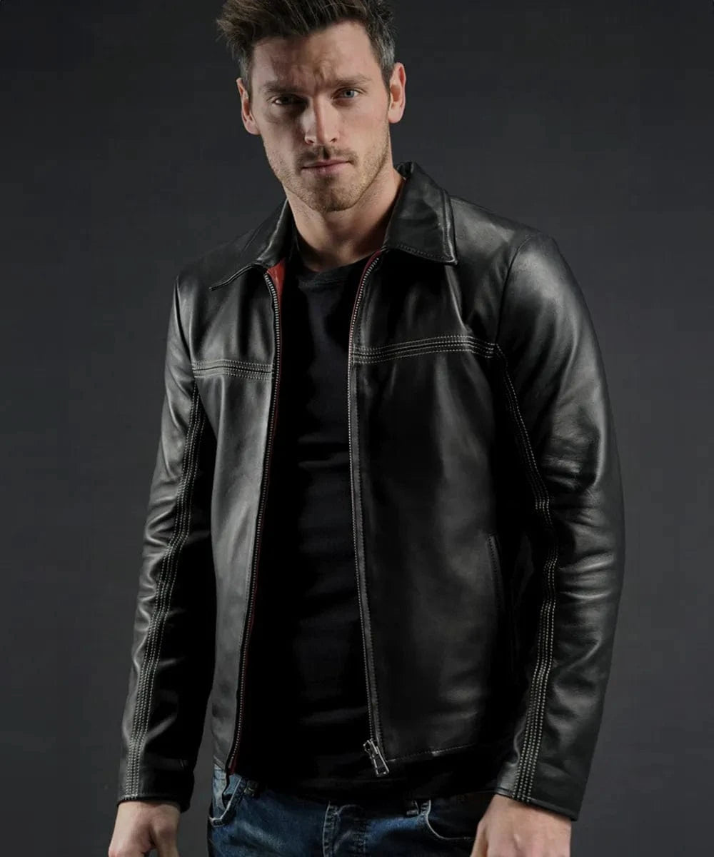 Male model wearing a black leather Layer Cake movie replica jacket with slim fit styling, vintage collar, contrast stitching, and minimalist zip front detailing over a black shirt