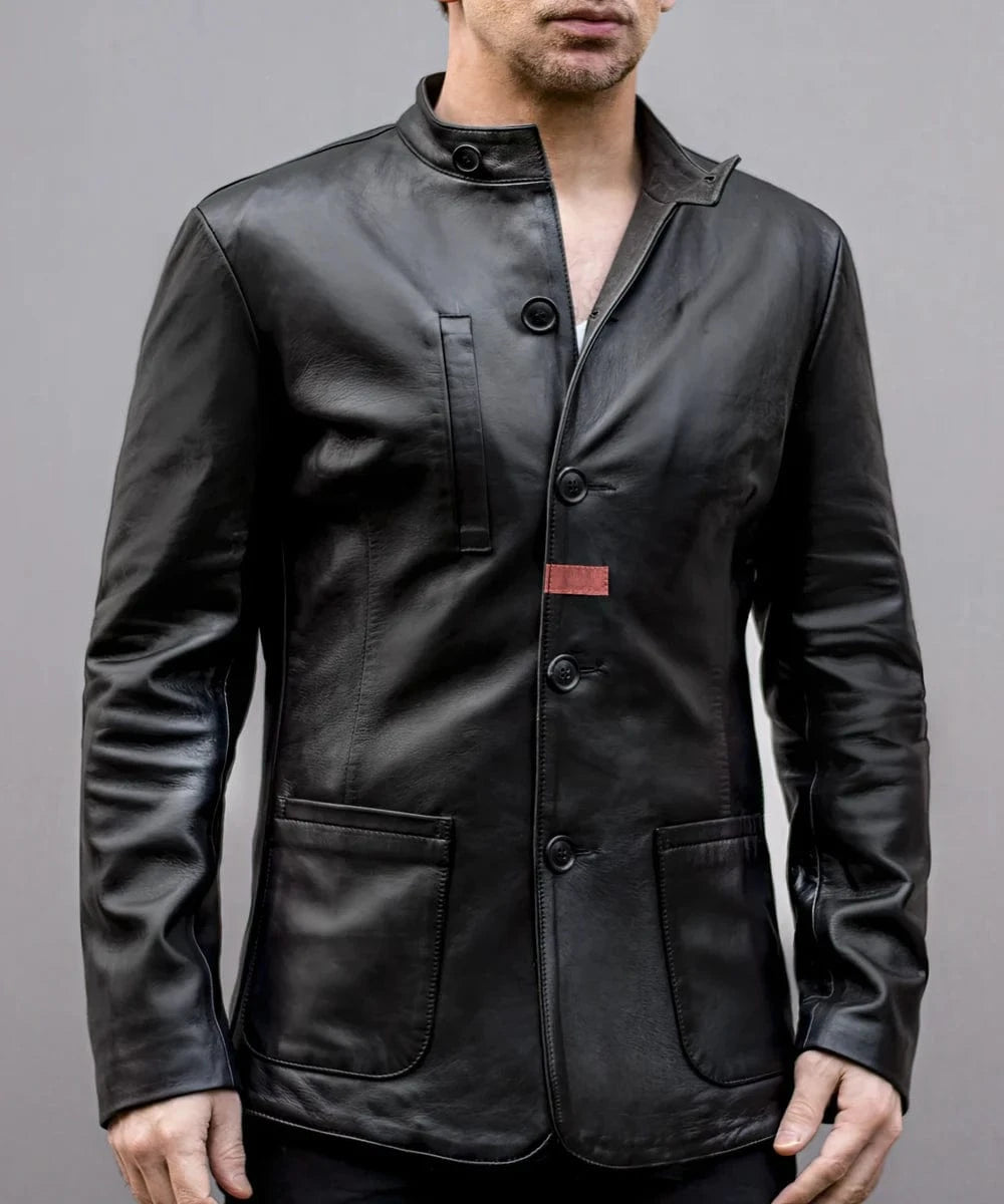 Model wearing black leather jacket with slim fit modern military styling, stand collar, concealed button placket, and minimalist design