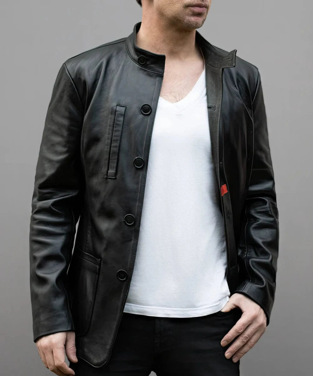 Model wearing black leather jacket with slim fit modern military styling, stand collar, concealed button placket, and minimalist design