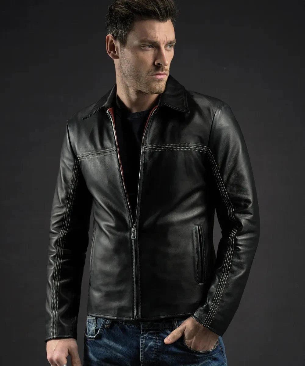 Male model wearing a black leather Layer Cake jacket with slim fit styling, vintage collar, contrast stitching, and minimalist zip front detailing paired with dark denim jeans