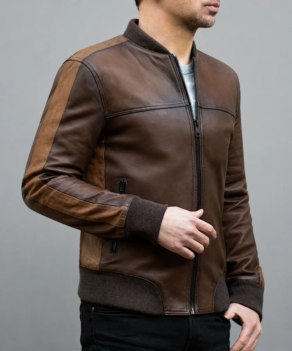 Model wearing vintage brown leather bomber jacket with slim fit styling, ribbed knit trim, and contrast leather panel detailing